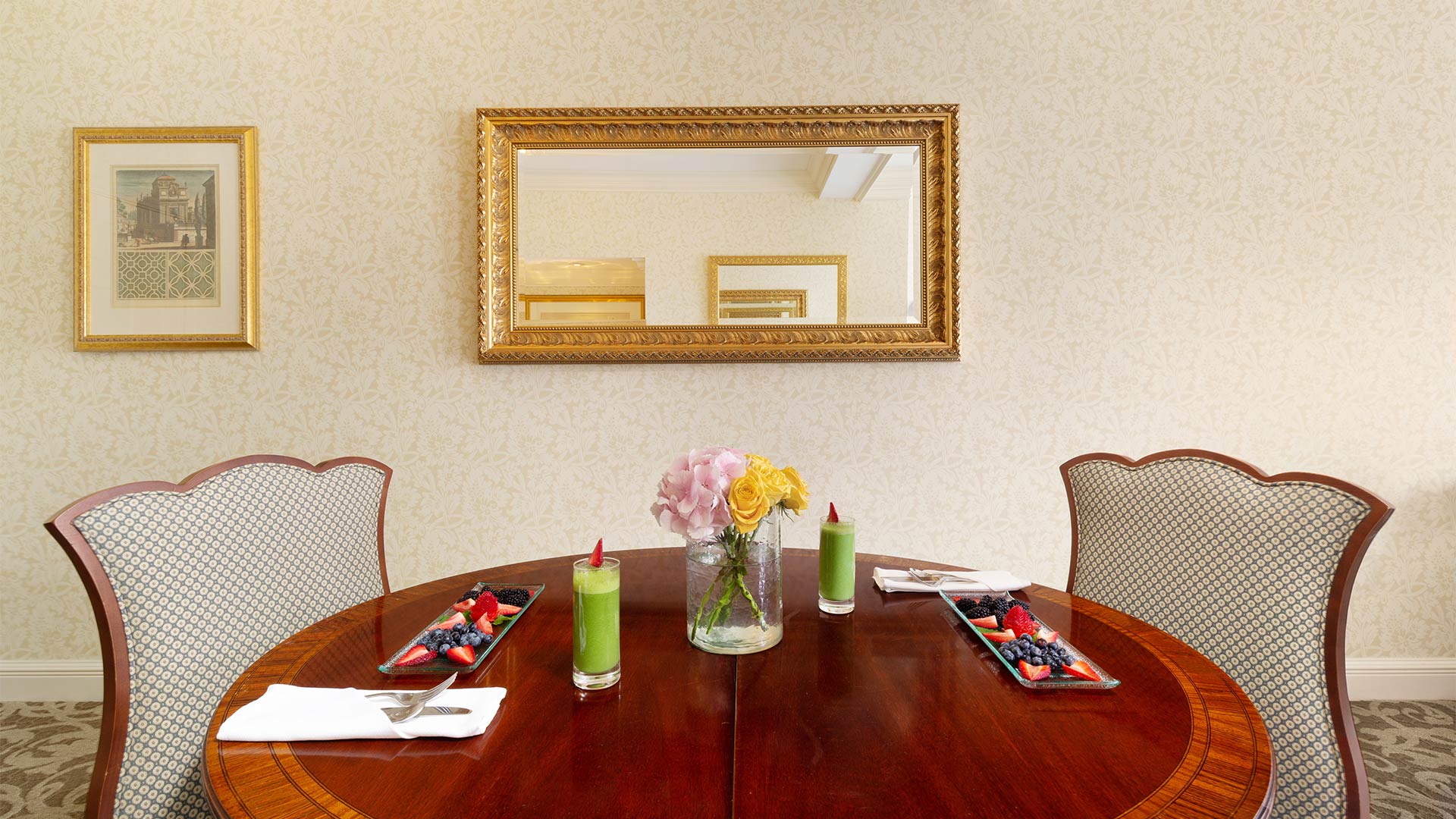 detail shot of the suite's dining area. Two chairs are placed around a circular table. There is breakfast on top of the table.