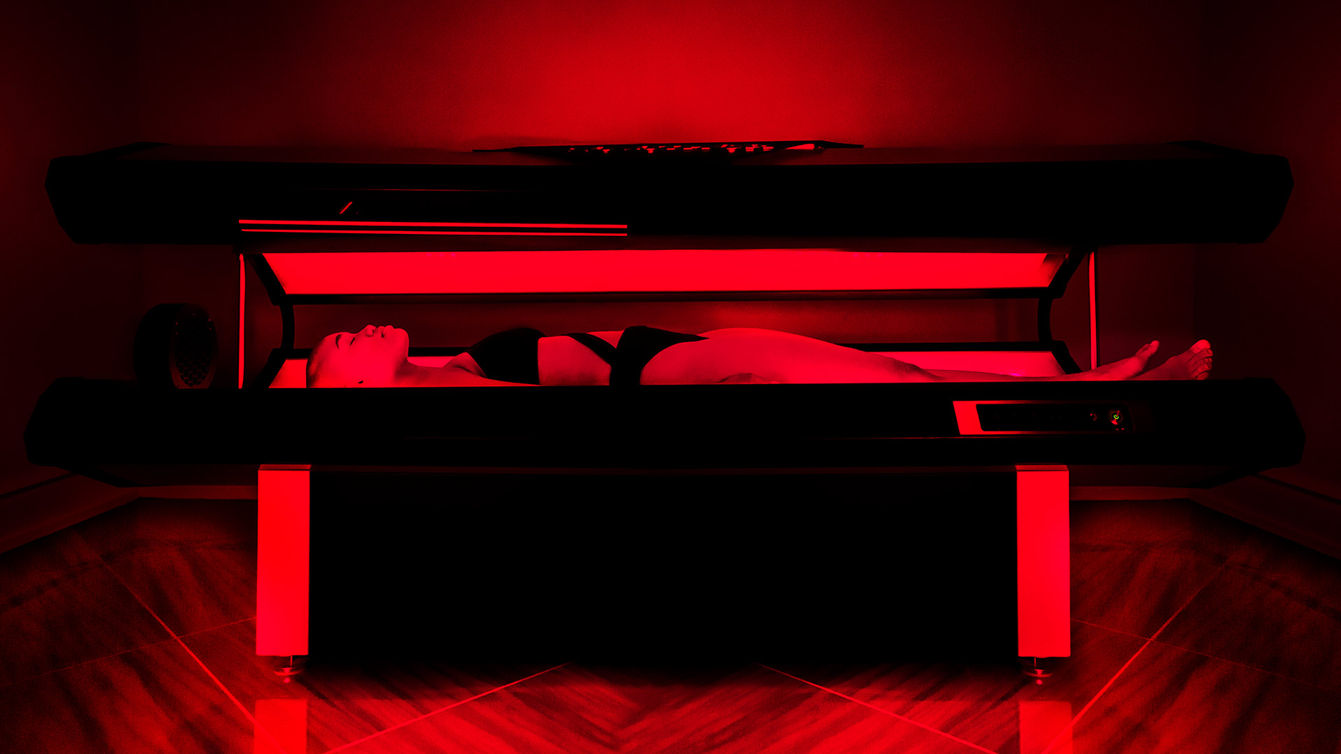 a woman is lying on her back in a chamber. There is infrared light shining on her