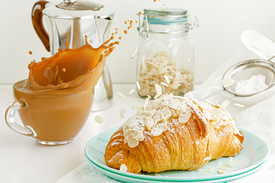 almond croissant with a splashing cup of coffee