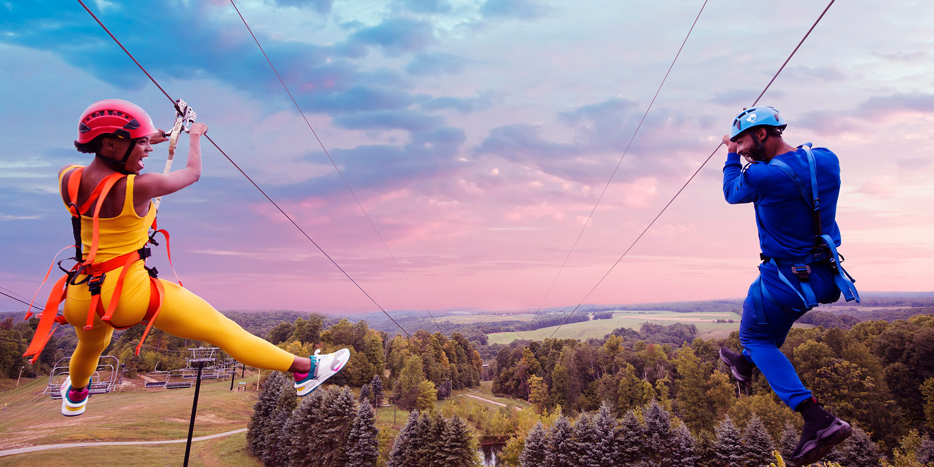 man and woman on a zipline parallel to one another