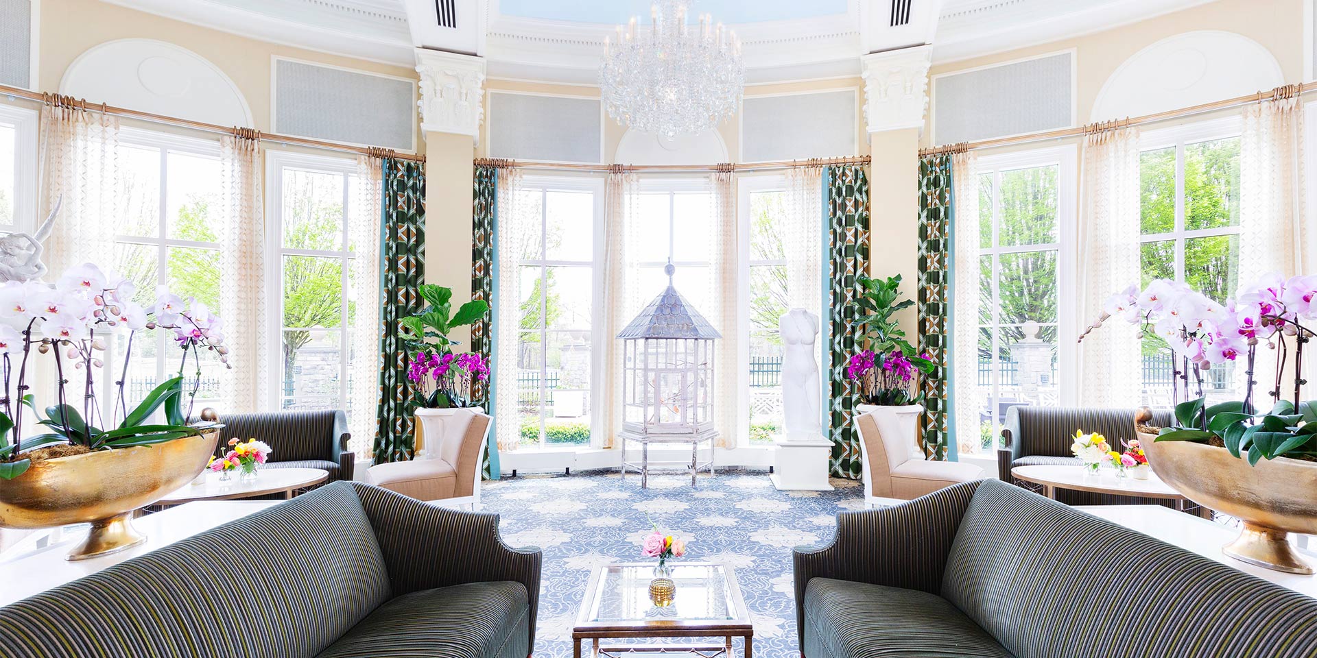 Beautiful room with picture windows, couches, a chandelier, flowers