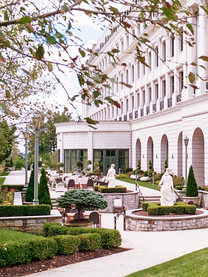 View of white building with a sculpture garden in front