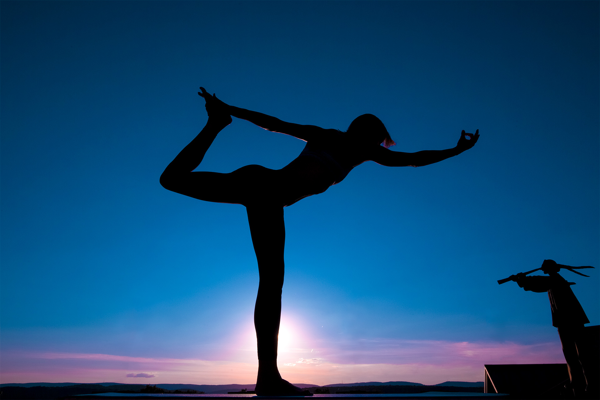 Silhouette of someone doing yoga at dusk