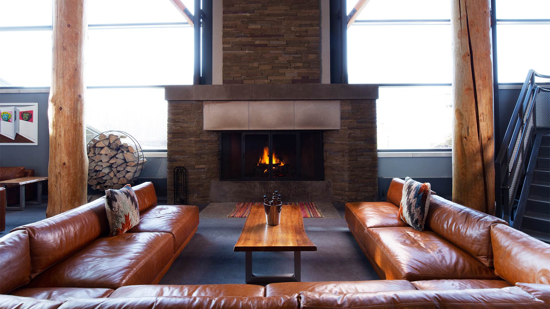 Brown leather seats in front of a fireplace.