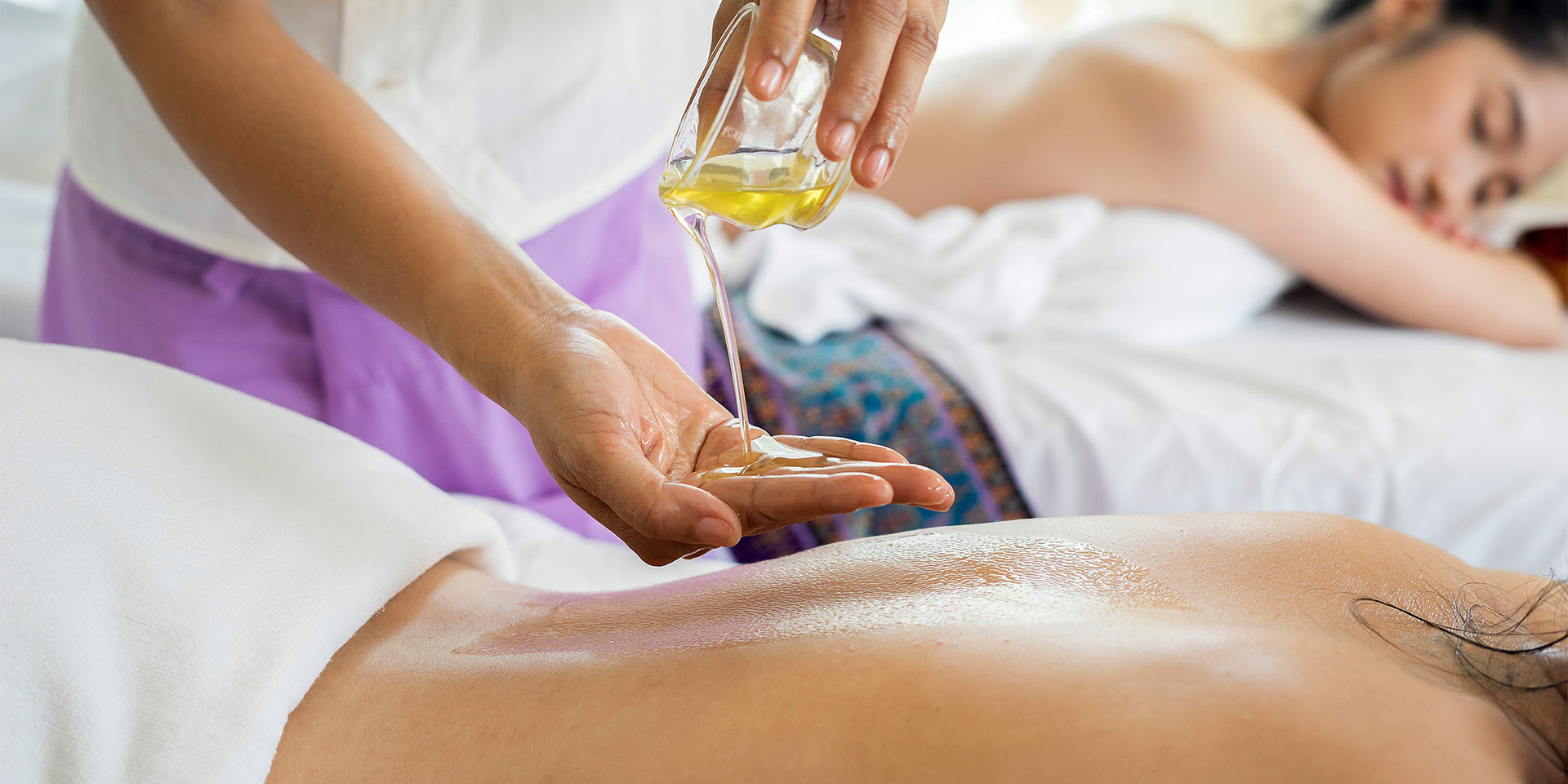 Massaging oil into a client's back.
